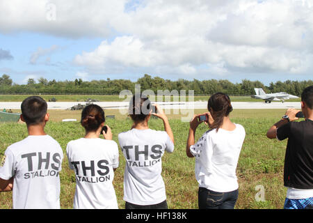 Schüler von Tinian High School Junior Reserve Officer Training Corps zusehen, wie ein FA - 18D Hornet hier eine verhaftete Landung auf Westfeld Dez. 7 während der Übung Forager Fury 2012 macht. Die JROTC Schüler erhielten eine Nahaufnahme Blick in Marine Luftfahrt während der ersten verhafteten Landungen für FF12 durchgeführt wurden. Das Flugzeug ist mit Marine alle Wetter Fighter Attack Squadron 225, die derzeit in der Einheit-Deployment-Programm mit Marine Aircraft Group 12, 1st Marine Aircraft Wing, III. Marine Expeditionary Force. (U.S. Marine Corps Foto von Lance Cpl. J. Gage Karwick/freigegeben) Tinian Cad Stockfoto