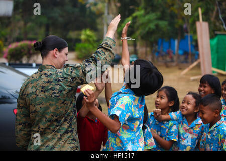 U.S. Marine Corps Lance Cpl. Kassie L. McDole, links, ein Kampf gegen Videofilmer mit Marine Corps Forces Pacific, High-Fives Studenten an einer Grundschule in Provinz Phitsanulok, Thailand, 25. Januar 2013, während ein engineering Bürgerbeteiligung-Programm als Teil der Übung Cobra Gold 2013. Kobra-Gold ist eine regelmäßig stattfindende Gelenk/kombinierter Übung sollen regionalen Frieden zu gewährleisten und die Stärkung der Fähigkeit der königlichen thailändischen Streitkräfte zu verteidigen Thailand oder auf regionalen Eventualitäten reagieren. (DoD Foto von Lance Cpl. Andrew Kuppers, US Marine Corps/freigegeben) 130125-M-NT768-014 (8430014410) Stockfoto