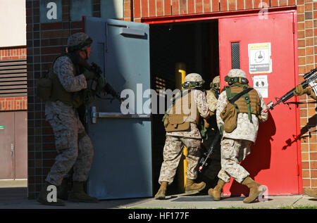 Marines Sturm durch eine Tür während einer Übung gehaltenen 2. Wartung Bataillon, 2. Marine Logistik Gruppe an Bord Camp Lejeune, North Carolina, 27. März 2013. Die Einheit Personal angegriffen die Verbindung für mehr als eine Stunde vor der Beseitigung der simulierten terroristische Bedrohung. Keine Gefangenen trainieren Marines, Anlage von Terroristen 130327-M-ZB219-159 zurückzuerobern Stockfoto