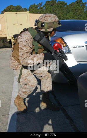 Eine Marine vorsichtig macht seinen Weg durch einen Parkplatz bei einem simulierten Terroranschlag am 2. Wartung Bataillon, 2. Marine Logistics Group Verbindung an Bord Camp Lejeune, North Carolina, 27. März 2013. Das Bataillon Servicemembers verbrachte mehr als eine Stunde Eingriff ihre Altersgenossen in simulierten Häuserkampf während der Übung. Keine Gefangenen trainieren Marines, Anlage von Terroristen 130327-M-ZB219-224 zurückzuerobern Stockfoto