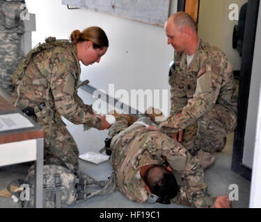 Lt. j.g. Laura Cargill und Senior Chief Petty Officer William Lewis, Provincial Reconstruction Team 13-17, Provinz Uruzgan, behandeln ein PRT-Kollege während ein Trainingsszenario simulieren einer Verletzung nach einem mock Mörtel-Angriff gegen eine vorgeschobene operative Basis an Atterbury-Muscatatuck in der Nähe von Edinburgh, ind., 8 Mai. Die PRT unterzog diese Übung als Teil ihrer Mobilisierung. (Foto von Ashley Roy, Atterbury-Muscatatuck Public Affairs) Für FHM Schwerpunkt medizinische Ausbildung Übergang 130508-Z-KN828-062 Stockfoto