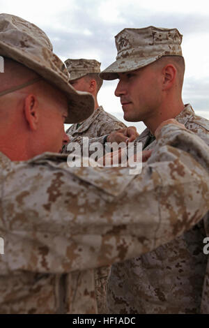 Ersten Lt. Stefan Milan, ein Brooklyn, N.Y., native und Assistent zukünftige Operationsoffizier mit Sitz und Unterstützungskompanie, Combat Logistik-Bataillon 6, 2. Marine Logistics Group, pins auf den Rang eines First Lieutenant während einer Promotion-Zeremonie in Twentynine Palms, Kalifornien, 27. Mai 2013. Mailand Stand auf einem windgepeitschten Berg und bekräftigte seinen Amtseid am Rande der Operation Enduring Freedom bereitstellen. Brooklyn Native bekräftigt Eid vor der Bereitstellung 130527-M-ZB219-011 Stockfoto