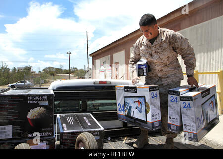 Marine Corps CPL. Mark Daoud, Assistent Facility Manager für das gemeinsame Task Force Direktion Logistik-Gehäuse-Team lädt Fernseher und andere elektronische Geräte auf einen Tieflader, 1. Juli 2013 am US Naval Station Guantanamo Bay auf Kuba. Daoud, ein Twin Lakes, Wisconsin. Native, arbeitet mit dem Gehäuse Personal Gehäuse Essentials mehr als 1.700 Joint Task Force Guantanamo Bay Personal anzubieten. (Armee Nationalgarde Foto von Sgt. Cassandra Monroe/120. Public Affairs Abteilung/JTF-GTMO Public Affairs) Marine Corpsman unterstützt mit Gehäuse Bemühungen bei GTMO 130701-Z-FT114-001 Stockfoto