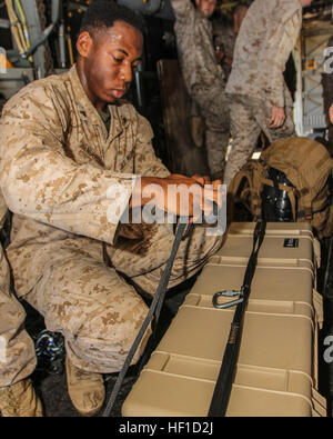 US Marine CPL. Jesaja Henderson, gebürtig aus Oakland, Kalifornien, und Feldartillerie Cannoneer Battalion Landing Team 3/2, 26. Marine Expeditionary Unit (MEU), Bindungen, die ein Knoten gleichzeitig sichern ein Pelikan Fall gesichert werden, während der Durchführung Hochseilgarten Suspension Training in einer statischen MV-22 Osprey auf USS Kearsarge (LHD-3), am Meer, 23. Juli 2013 zugewiesen. Die 26. MEU ist eine Marine Air-Ground Task Force vorwärts in den USA bereitgestellt 5. Flotte Aufgabengebiet an Bord der Kearsarge amphibische bereit Gruppe als eine seegestützte, expeditionary Krisenreaktion Kraft fähig amphibische Operat Stockfoto