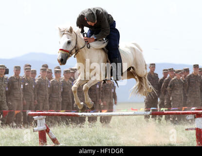 Mitglied der mongolischen Streitkräfte 234 Kavallerie-Einheit, springt sein Pferd während der Eröffnungsfeier der Übung Khaan Quest in fünf Hügeln Trainingsbereich, Mongolei, 3. August 2013. Khaan Quest ist eine jährliche multinationalen Übung gesponsert von den Vereinigten Staaten und der Mongolei, und es soll die Kapazitäten der USA, mongolischen und anderen Nationen Kräfte in internationalen Friedenseinsätzen. (US Marine Corps Foto von Sgt John M. Ewald/freigegeben) Khaan Quest 2013 - Eröffnungsfeier (Bild 8 von 26) (9442793555) Stockfoto