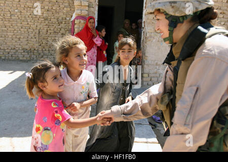 070928-M-0984M-006 KABANI, Irak (28. September 2007) - CPL. Julia Venegas, befestigt auf 2D Marine Logistics Group, schüttelt Hände mit einem kleinen Mädchen auf einer Sicherheitspatrouille. 2D Marine Logistics Group ist in der Al Anbar Provinz zu entwickeln, die irakischen Sicherheitskräfte eingesetzt. US Marine Corps Foto von Lance Cpl. Robert S. Morgan (freigegeben) U.S. Navy 070928-M-0984M-006 CPL. Julia Venegas, befestigt auf 2D Marine Logistics Group, schüttelt Hände mit einem kleinen Mädchen auf einer Sicherheitspatrouille Stockfoto