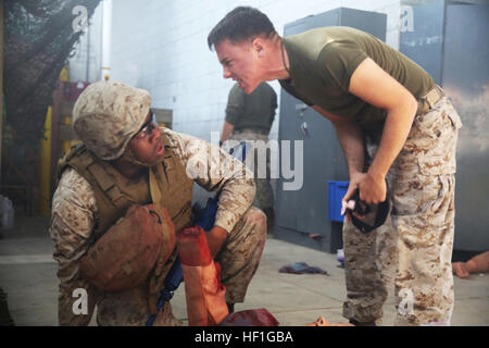 Petty Officer Third Class Joshua O'Hara (rechts) schreit bei einem Student über die ordnungsgemäße Tourniquet Platzierung im Verlauf taktische Combat Casualty Care/Combat Lebensretter an Bord Camp Lejeune, North Carolina, 26. September 2013. Geschrei, Explosionen und lauten Sound-Effekte waren nur einige der Werkzeuge der TCCC/CLS-Kurs genutzt, um den Stress des Schlachtfeldes in einem Klassenzimmer bringen. (Foto: U.S. Marine Corps Lance Cpl. Shawn Valosin) Chaos und Verwirrung bringt Marine Kurs Schlachtfeld Stressoren ins Klassenzimmer 130926-M-IU187-210 Stockfoto