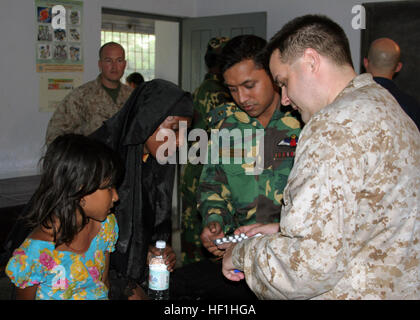 Lt. CMdR Trey Hollis, Chefarzt von der 22. Marine Expeditionary Unit (MEU) (spezielle Operationen fähig), medizinischen Hilfe an Opfer von tropischer Zyklon Sidr in der provisorischen Notaufnahme am Rangabali College, Süden von Bangladesch rendert. Die amphibischen Angriff Schiff USS Kearsarge (LHD-3) und der 22. MEU (SOC) sind Bereitstellung humanitärer Hilfe auf Ersuchen der Regierung von Bangladesch für die Opfer des tropischen Wirbelsturms Sidr, die durch Bangladesch, 15. November Riss. Ärzteteam bietet Hilfe für mehr als 200 Menschen DVIDS66787 Stockfoto