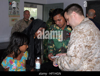 071129-M-3095K-294 Bangladesch (27. November 2007) Lt. CMdR Trey Hollis, Chefarzt an der 22. Marine Expeditionary Unit (MEU) (spezielle Operationen fähig), rendert medizinischen Hilfe an Opfer von tropischer Zyklon Sidr in der provisorischen Notaufnahme am Rangabali College, Süden von Bangladesch. Die amphibischen Angriff Schiff USS Kearsarge (LHD-3) und der 22. MEU (SOC) sind Bereitstellung humanitärer Hilfe auf Ersuchen der Regierung von Bangladesch für die Opfer des tropischen Wirbelsturms Sidr, die durch Bangladesch 15. November Riss. Foto: US-Marinekorps SGT Ezekiel R. Kitandwe (freigegeben) uns Marine 071129-M-3 Stockfoto