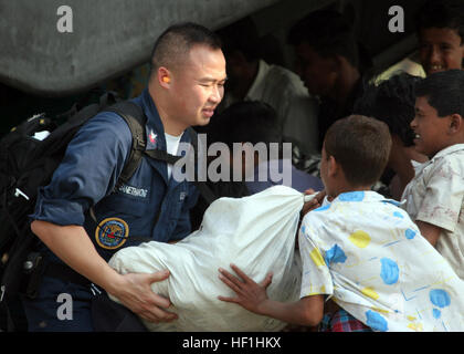 071201-M-3095K-169 RANGABALI, Bangladesch (1. Dezember 2007) A Bangladeshi lokalen erhält Lieferungen von Hospital Corpsman 1. Klasse Sam Sanethavong, Atemwege Techniker aus Portland, Oregon. Marines vom 22. Marine Expeditionary Unit (MEU) spezielle Operationen fähig (SOC) und Segler aus der amphibischen Angriff Schiff USS Kearsarge (LHD-3) leisten humanitären Hilfe im Zuge der tropische Wirbelsturm Sidr.  Sidr schlug die Küste von Bangladesh 15. November. Kearsarge und der eingeschifften Elemente des 22. MEU (SOC) kam vor der Küste von Bangladesch 23 November zur Unterstützung der laufenden Relief ef Stockfoto