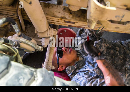 SPC. Marvyn Ortiz, Radfahrzeug Mechaniker in Unternehmen B, Sitz und Sitz-Bataillon, 4. US-Infanteriedivision, inspiziert die Unterseite eines Fahrzeuges am 4. Inf. Div. Fuhrpark Kandahar airfield, Afghanistan, am 15. Oktober. Mechaniker arbeiten um sicherzustellen, dass Fahrzeuge in der Lage und bereit, Transport-Soldaten in dem Schlachtfeld sind. (US Armee-Foto von CPL. Clay Beyersdorfer) Leben in der Mechaniker-Shop 131018-Z-HP669-631 Stockfoto