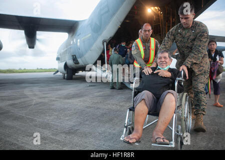 1st Lt. Josiah Stephen, ein Geheimdienst-Offizier Marine Aerial Refueling Transport Geschwader 152, aktuell zugewiesene 3d Marine Expeditionary Brigade und ein Eingeborener von Valdosta, Georgia, hilft einen philippinische Zivilisten ein US-Marine c-130 Hercules-Flugzeuge auf Villamor Air Base, 12. November entlasten. Space-Marines und Segler mit 3d Marine Expeditionary Brigade unterstützen der philippinischen Streitkräfte bei der Bereitstellung von humanitärer Hilfe und Katastrophenschutz in den betroffenen Gebieten in der gesamten Republik der Philippinen nach Taifun Haiyan/Yolanda. (Foto: U.S. Marine Corps CPL. Codey Underwood) T Stockfoto