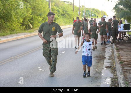 1st Lt. Alex Cloninger läuft neben Harry Fang, 8, die den Lauf mit einer Zeit von 24 Minuten 14 Sekunden während der 2. Tinian Hafa Öksüz 5 K beendet 30. November laufen, Fang fertig gestellt, bevor eine andere Person von Tinian in seiner Altersklasse. Cloninger ist ein motor Transport-Offizier mit Marine Wing Support Squadron 171, Marine Aircraft Group 12, 1st Marine Aircraft Wing, III. Marine Expeditionary Force. Cloninger und die andere MWSS-171-Service-Mitglieder sind derzeit auf Tinian Teilnahme an Übung Forager Fury II, die eine gemeinsame Übung, konzipiert ist. (US-Marine Foto von CPL. J. Gage Karwick/freigegeben) Stockfoto