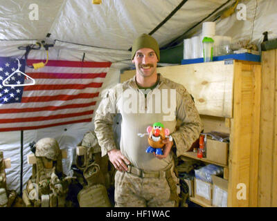 Petty Officer 3rd Class Kristopher Krysa, 27, aus La Grange Park, Illinois, ein Corpsman mit Security Force Unterstützung Beraterteam 2-215, hält seine Mr. Potato Head Spielzeug an Bord der Forward Operating Base Nolay, Provinz Helmand, Afghanistan, Jan. 2014. Krysa erhalten die Mr. Potato Head zu helfen Boost Moral und halten alle Lächeln. E28098Doc BruteE28099 trainiert, berät, unterstützt afghanische medizinisches Personal 140128-M-PF875-503 Stockfoto