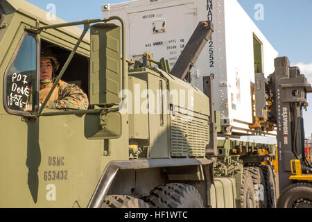 Lance Cpl. Austin Tarter, motor Transport Operator mit Marine Wing Support Squadron 171, Ansichten in seinem Spiegel während andere Marines eine mobile Anlage auf ein Logistik Fahrzeug System Ersatz MKR-18 Frachtfahrzeug an Bord der Marine Corps Air Station Iwakuni, Japan, 15. Januar 2014 geladen. Hap-171-Treiber unterstützen Betreiber in MALS-12 Verlagerung 140115-M-BZ918-062 Stockfoto