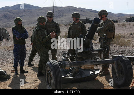 Japanischer Oberst Matsushi Kunii, Mitte links, befehlshabender Offizier, westlichen Armee-Infanterie-Regiment, beschreibt die Fähigkeiten des High-Explosive Rocket-Assisted Geschosses mit US Marine Lieutenant Colonel John O'Neal, befehlshabender Offizier, 15. Marine Expeditionary Unit und Lieutenant Colonel Brian Russell, befehlshabender Offizier, 1. Naval Gunfire Liaison Fluggesellschaft, während Übung Iron Fist 2014 an Bord Twentynine Palms, Kalifornien, 28. Januar 2014.  Iron Fist-2014 ist eine amphibische Übung die Marines und Segler aus dem 15. MEU, andere ich Marine Expeditionary Force Einheiten und Soldaten von der Japan zusammenbringt Stockfoto