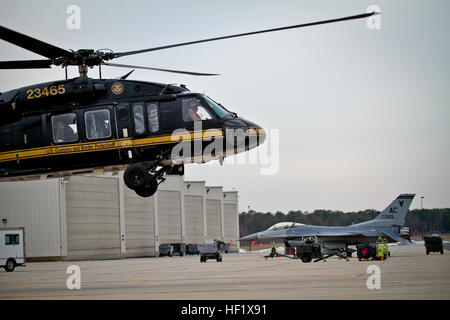 Ein U.S. Customs and Border Protection UH-60 Black Hawk Hubschrauber hebt ab, wie eine F - 16C Fighting Falcon von der New Jersey Air National Guard 177. Kämpfer-Flügel im Hintergrund geparkten am 28. Jan. in Atlantic City Air National Guard Base, N.J.  Die US Customs and Border Protection verbrachte den Tag informieren die Medien über die Rolle, die sie als Bestandteil der Gesamtkraft Aufwand für Sicherheit am Super Bowl XLVIII spielen werden.  (U.S. Air National Guard Foto von techn. Sgt. Matt Hecht/freigegeben) 177. Jagdgeschwader beteiligt sich abfangen Übung vorzubereiten gemeinsame Team für Super Bowl XLVIII 140128-Z Stockfoto