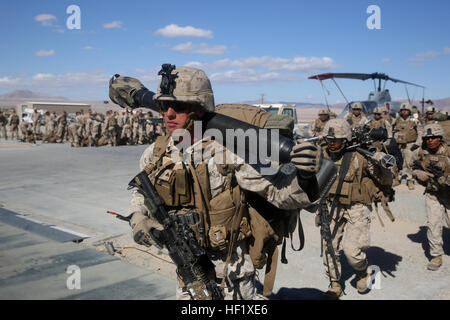 Corporal Colin Schafer, Mortarman Waffen Firma, 1. Bataillon, 7. Marineregiment und ein Eingeborener von Eugene, Oregon/USA, trägt eine 81 mm Mörser Röhre wie er auf ein CH-46 Sea Knight Hubschrauber im Marine Corps Air Ground Combat Center Twentynine Palms, Kalifornien, 3. Februar 2014 lädt. Marines wurden zwei Kilometer vom Lava-Trainingsbereich eingefügt, wo sie Feuer und über unwegsames Gelände zu einem Ziel zu manövrieren und Verteidigungsstellungen einrichten mussten. Nach der Verteidigung der Region für 36 Stunden, die Infanteristen ein feindlicher Nachtangriff abgestoßen und einen Gegenangriff über fünf Kilometer, die drei abzuschließen ausgeführt Stockfoto