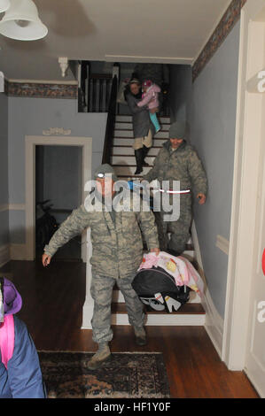 Georgia National Gardist Master Sgt. David Wilburn mit dem 165. Air Lift Flügel, Georgia Air National Guard, trägt 4 Monate alten D'kota die Treppe hinunter, während einer Mission, um eine Familie aus einem Haus zu evakuieren, die Strom- und Wärmeerzeugung durch Winter Sturm Pax verloren. (US Army National Guard Foto von Sgt. Michael Uribe/freigegeben). Betrieb Snowball III 140212-Z-XA030-095 Stockfoto