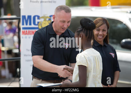 Oberst Peter D. Buck, Kommandierender Offizier der Marine Corps Air Station Beaufort, gratuliert Aja Wells, der Erstplatzierte des Kindes Missbrauch Bewusstsein Plakatwettbewerb während Kid es Fest 2014 in Beaufort County April 5, 2014. Kid es Fest soll Bewusstsein für Kindesmissbrauch und verwahrloste Kinder im Laufe des Monats April. (Foto: U.S. Marine Corps Lance Cpl. Patrick J. McMahon/freigegeben) Kid es Fest 2014 140405-M-VR358-144 Stockfoto