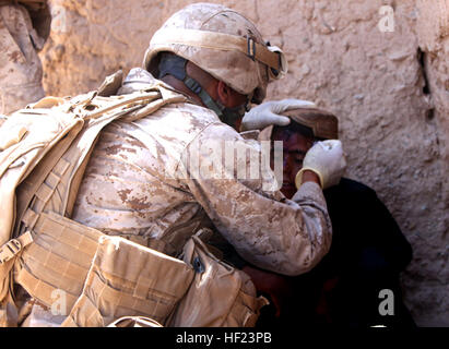 Petty Officer 1st Class Freddy Mejia, Sanitätern mit Alpha Company, 1. Bataillon, 2. Marine Regiment, Regimental Combat Team 2, inspiziert eine Senkung auf Khalids Stirn jetzt Zad Mai 19. Khalid, ein afghanischer Junge fiel ein Motorrad am Vortag und den Kopf verletzt. Während einer Patrouille, Marines entdeckt der junge und brachte ihn zu den Sanitätern, den Verband zu überprüfen. Mejia, eine 30 Jahre alte gebürtige Puerto Rico, bestimmt er könnte helfen, den jungen, die Wunde gereinigt und einen frischen Verband angewendet. Das Dorf hat einen afghanische Arzt, aber Marines noch bieten medizinischen Versorgung, wenn nötig. (Offizielle US-Mar Stockfoto