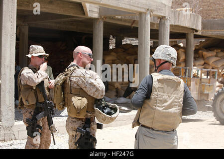 Wilmer Snell, dem United States Department of Agriculture Vertreter für den Bezirk Garmsir gibt Major Anthony Frank, der 1. Marine Division (FWD) Entwicklung Offizier und Kapitän Thomas McAvoy, zivile Angelegenheiten Gruppenleiter 3. Bataillon, 1. Marineregiment, eine Tour der alten Berufsschule jetzt dient als Standort für Saatgut-Verteilung-Programme. Marines Umfrage Garmsir für neue Berufsschule DVIDS284049 Stockfoto