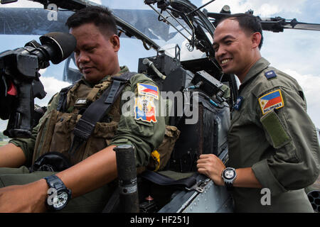 Philippine Flieger mit der 18. Angriff Geschwader, 15. Fighter Wing in Sangley Air Base, Sangley Point, Cavite City stationiert beobachten einer AH-1W Pkw mit Marine Light Attack Helicopter Squadron 469, Marine Aircraft Gruppe 39, 3rd Marine Aircraft Wing, Sitz in Camp Pendleton, Kalifornien, während eines Fluges Einarbeitung während Balikatan 2014 bei Clark Air Base, Mabalacat, Republik der Philippinen, Mai 12 , 2014. Dieses Jahr markiert die 30. Iteration der Balikatan, die eine jährliche Republik der Philippinen und den USA bilaterale Militärausbildung Übung ist. (U.S. Marine Corps Foto von Lance Cpl. Alli Stockfoto