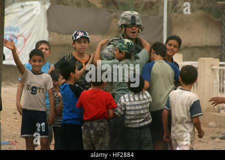 Ein US-Soldat von Charlie Kompanie, 30. Infanterie-Regiment, 2nd Battalion, 4th Brigade Combat Team, 10th Mountain Division erhält Abschied Umarmungen aus einer Gruppe von jungen Leben in einer palästinensischen Gemeinschaft in Baladiyat, östlichen Bagdad, 14. September 2008. Seine Einheit, zusammen mit irakische Nationalpolizei, waren dort humanitäre Hilfe Taschen zu helfen, Pflege gute Beziehungen mit der palästinensischen Gemeinschaft austeilen und die irakischen Sicherheitskräfte während des Ramadan. Flickr - DVIDSHUB - humanitäre Hilfe in Baladiyat Stockfoto