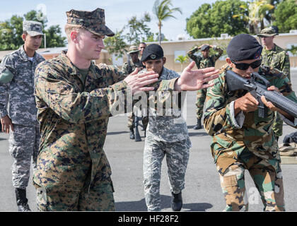 U.S. Marine CPL Joseph Zimmerman, mit Charley Gesellschaft, 4. Law Enforcement Bataillon, Kräfte Meeresschutzgebiet, Trainer Mitglieder aus 13 Partnerstaaten über innere urbanen Taktik Training, innere enge Quartal Schlachten und Zimmer Lichtungen Tradewinds 2014 an Bord Dominikanische Naval Base, Las Calderas, befindet sich in der Nähe von Bani, Dominikanische Republik, 19. Juni 2014. US-Marines mit Charley Gesellschaft, 4. Law Enforcement Bataillon, zwingt Meeresschutzgebiet und Soldaten mit der kanadischen Armee bilden Polizeikräfte aus 13 Partnernationen Teilnahme an Tradewinds Phase II Field Training Exercise hel Stockfoto