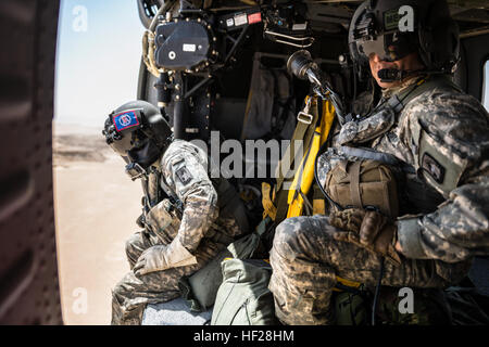 Überwachen Sie SPC. Nicholas Mouyos, Flug Medic und Spc. Giles Dunlop, Crewchief, ihre Umgebung nach einer simulierten Casulaty zu retten, während ein Personal Recovery Übung zwischen einem UH-60 Black Hawk am 19. Juni 2014, in Kuwait von Unternehmen C, 1. Bataillon, 214th Air Ambulance, 42. Combat Aviation Brigade (CAB) und eine kuwaitische Luftwaffe SA 330 Puma Hubschrauber geflogen. 42. CAB und kuwaitischen Streitkräfte führen regelmäßig gemeinsame Partnerschaften ein, um ihre Fähigkeit zur Reaktion auf Notfälle zu verbessern. Die 42. CAB, New York Army National Guard, ist nach Kuwait zur Unterstützung der Operation Enduring Fre bereitgestellt. Stockfoto