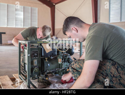 U.S. Marine Lance Cpl. Ross Brown, MP, Company C, 4. LEB und U.S. Marine Lance Cpl. Cormac Kavanaugh, MP, Firma C, 4. LEB schauen vorbei und einen Ersatz-Generator während Tradewinds 2014 Schießstand an Bord der Dominikanischen Naval Base, Las Calderas, befindet sich in der Nähe von Bani, Dominikanische Republik, 22. Juni 2014 zu reinigen. Inventar der gesamten Ausbildung und trainingsfreien Ausrüstung muss entfielen und weggepackt vor der Verladung in den Joint High-Speed-Schiff, das dann das Gerät an seinen ehemaligen Bestimmungsort zurück. US-Marines mit Charley Gesellschaft, 4. Law Enforcement Bataillon, Marine Forces Reserve, ein Stockfoto