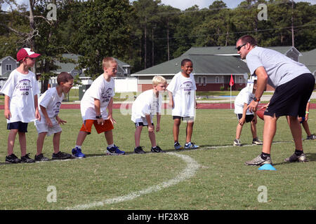 Andrew Gurley lehrt einer Gruppe von Campern die richtige Linebacker Haltung während der Steve Smith ProCamp im Marine Corps Air Station Cherry Point, North Carolina, 24. Juni 2014. Die Installation wurde ausgewählt, um das Lager zum zweiten Mal nach dem Gewinn eines Wettbewerbs zwischen Kommissare im ganzen Land zu hosten. Gurley ist ein Offensive Line Coach an Croatan High School. Steve Smith inspiriert Cherry Point Jugend 140624-M-BN069-018 Stockfoto