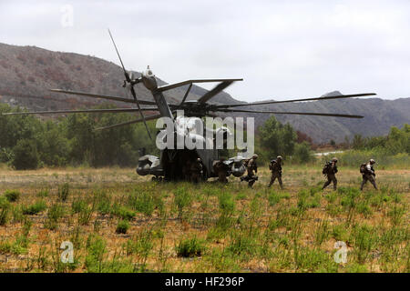 Ein CH-53E Super Stallion mit Marine schwere Hubschrauber Geschwader (HMH) 465 wartet als Marines vom 1. Bataillon, 1. Marineregiment, das Flugzeug nach extrahiert aus einem objektiven Bereich während der Ausbildung an Bord der Marine Corps Base Camp Pendleton, Kalifornien, 27 Juni verlassen.  Die Übung wurde durchgeführt, so dass Piloten und Bodeneinheiten Kommunikationstechniken miteinander anwenden könnte. HMH-465 führt RAID-Übung mit Boden Einheiten 140627-M-CJ278-512 Stockfoto