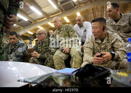 Afghan National Army (ANA) gen Shir Mohammad Karimi, links, Leiter des Armee-Personals; US Armee Generalleutnant Joseph Anderson, Center, Kommandeur der International Security Assistance Force (ISAF) Joint Command (IJC); US Marine Corps Major General Daniel D. Yoo, Recht, Kommandant des Regional Command (Südwest); Generalmajor Daniel J. O'Donohue, oben rechts, stellvertretender Leiter der Operations für die ISAF; Peer über eine Karte Südwesten Afghanistans an Bord Camp Shorabak, Provinz Helmand, Afghanistan, 27. Juni 2014. Karimi besucht mit ANA Führer und ISAF-Berater der militärischen Angelegenheiten in der südwestlichen Region zu diskutieren Stockfoto