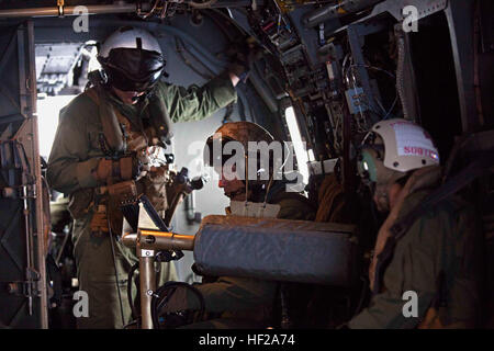 Corporal Eric Cotter (Mitte), MV-22 Crewchief mit Marine Operational Test und Auswertung Geschwader 22 (VMX-22), greift simulierten feindliche Ziele mit CPL. Jeramiah Serfling (links), auch ein MV-22 Crewchief VMX-22, während eine Funktionsprüfung an Bord ein MV-22 Osprey, 14. Juli 2014. Die Crew von VMX-22 der g-22-Konfiguration des defensiven Waffensystem, die GAU-17 Minigun auf den Bauch des Flugzeugs montiert nutzt getestet. VMX-22 ist derzeit zur direkten Unterstützung der besonderen Zweck Marine Air Ground Task Force Süd an Bord der zukünftigen amphibischer Angriff Schiff USS America (LHA-6) auf er Stockfoto