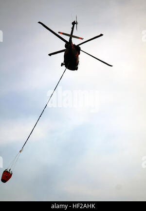 Soldaten aus der 66. Theater Aviation Command, Washington Army National Guard, bringen UH-60 Black Hawk Hubschrauber um mehr Wasser abholen, gegen Waldbrände tobt in der Nähe von Winthrop, Washington, 18. Juli 2014. Der National Guard verfügt über insgesamt sechs Hubschrauber in der Gegend um Feuerwehrleute vor Ort zu unterstützen. (Foto von Sgt. 1. Klasse Jason Kriess) Soldaten kämpfen Waldbrände vom Himmel 140718-Z-IK464-005 Stockfoto