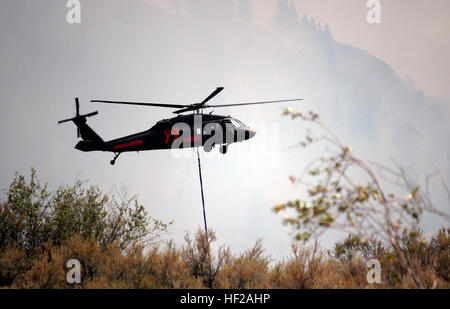 Soldaten aus der 66. Theater Aviation Command, Washington Army National Guard, bringen UH-60 Black Hawk Hubschrauber um mehr Wasser abholen, gegen Waldbrände tobt in der Nähe von Winthrop, Washington, 18. Juli 2014. Der National Guard verfügt über insgesamt sechs Hubschrauber in der Gegend um Feuerwehrleute vor Ort zu unterstützen. (Foto von Sgt. 1. Klasse Jason Kriess) Soldaten kämpfen Waldbrände vom Himmel 140718-Z-IK464-006 Stockfoto