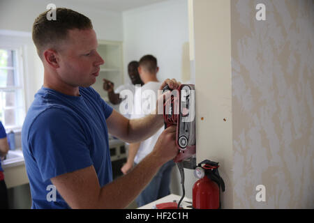 Eine Marine mit 1. Bataillon, 10. Marine Regiment, 2. Marine-Division Sand hinunter eine Küchenwand während ein Renovierungsprojekt in Jacksonville, NC, 31. Juli 2014. Ca. 20 Service-Mitglieder aus dem Bataillon freiwillig zu helfen, ein Bereich Zuhause als Bestandteil einer United Way Zeitspenden zur Verbesserung die örtliche Gemeinde zu renovieren. 10. Marines verleiht eine helfende Hand 140731-M-SF718-115 Stockfoto