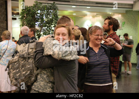 Alaska Army National Gardist Spc. Caleb Schneck, ein Militärpolizist mit 297th Military Police Company, umarmt seine Schwester Abby Schneck nach der Ankunft am internationalen Flughafen von Ted Stevens Aug. 2 nach einer 11-Monats-Bereitstellung in Guantanamo Bay auf Kuba. Die Gardisten bereitgestellt im September letzten Jahres in Guantanamo Bay zur Unterstützung der Operation Enduring Freedom als Teil der Joint Task Force-GTMO gemeinsame Haft Group. (US Army National Guard Foto von Sgt. Balinda O'Neal/freigegeben) Alaska-Gardisten zurück aus Guantanamo Bay Bereitstellung 140802-Z-CA180-006 Stockfoto