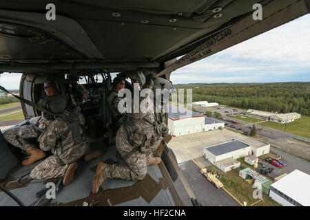 Alaska Armee National Gardist Sgt. Brian Lyman, Crewchief mit B Company, 1. Bataillon, 207. Aviation Regiment blickt auf Bryant Army Airfield aus einer Alaska Army National Guard UH-60 Black Hawk Hubschrauber Aug. 6 auf der gemeinsamen Basis Elmendorf-Richardson. (US Army National Guard Foto von Sgt. Balinda O'Neal/freigegeben) Alaska-Gardisten unterstützen, mit Wasser-Landung in der Luft Gelenkoperation 140806-Z-CA180-001 Stockfoto