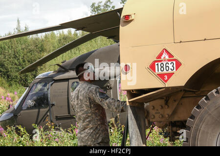 Alaska Armee National Gardist Sgt. Jason Nocelo, mit E-Company, 1. Bataillon, 207. Aviation Regiment beobachtet während der Betankung eines Alaska Army National Guard UH-60 Black Hawk-Hubschraubers in der Nähe von Big Lake Aug. 6 Kraftstoff DMS. Die AKNG 1-207th Aviation Regiment unterstützt 4th Infantry Brigade Combat Team (Airborne), 25. Infanterie-Division, bei einer ganztägigen Wasserlandung airborne Gelenkoperation. (US Army National Guard Foto von Sgt. Balinda O'Neal/freigegeben) Alaska-Gardisten unterstützen, mit Wasser-Landung in der Luft Gelenkoperation 140806-Z-CA180-101 Stockfoto