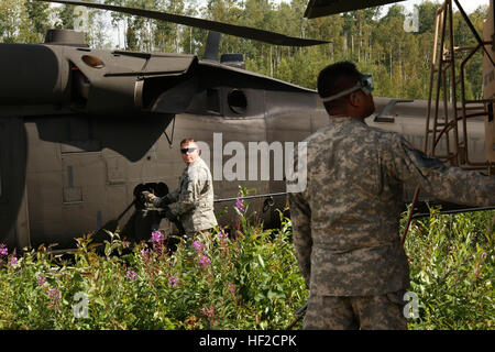 Alaska Army National Guard Erdöl Supply Specialist Spc. Kevin Miller, links, mit E-Company, 1. Bataillon, 207. Aviation Regiment, tankt einen Alaska Army National Guard UH-60 Black Hawk Hubschrauber während Sgt. Jason Nocelo, E Co., 1-207th AVN reg beobachtet Kraftstoff DMS in der Nähe von Big Lake Aug. 6. Die AKNG 1-207th Aviation Regiment unterstützt 4th Infantry Brigade Combat Team (Airborne), 25. Infanterie-Division, bei einer ganztägigen Wasserlandung airborne Gelenkoperation. (US Army National Guard Foto von Sgt. Balinda O'Neal/freigegeben) Alaska-Gardisten unterstützen, mit Wasser-Landung in der Luft Gelenkoperation 1408 Stockfoto