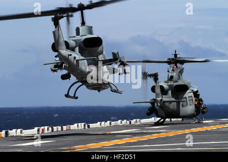 Ein AH-1W Kobra und ein UH-1Y Huey von Marine Medium Tiltrotor Geschwader 365 (Stahlbeton), 24. Marine Expeditionary Unit, abheben von der USS Iwo Jima vor der Küste von North Carolina, 11. August 2014. Die 24. MEU ist Teilnahme an amphibischen Geschwader/Marine Expeditionary Unit Integration oder PMINT, der 24. MEU zweiten großen Einsatzvorbereitenden Ausbildung ausüben. PMINT soll die Marines und Segler aus der 24. MEU und amphibischen Geschwader 8 zum ersten Mal an Bord der Schiffe der Iwo Jima amphibisches bereit Gruppe zusammenzuführen. (Foto: U.S. Marine Corps Lance Cpl. Dani A. Zunun) 24. MEU Stockfoto