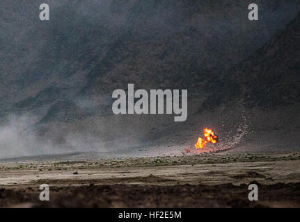 Eine Runde Artillerie detoniert am Fuße von einem entfernten Hügel südlich von Kandahar Flugplatz, Afghanistan, ausgelöst durch Alpha-Batterie, 2. Bataillon, 77. Feldartillerie-Regiment, 4th Infantry Brigade Combat Team, 4. US-Infanteriedivision, 22. August 2014. Die Runde war Teil eines Triebes, die 2-77 FA registrieren zu dürfen, oder Null und deren angebotenen Schulungen für ein Feuer und M777A2 Haubitzen support-Team von Delta Company, 1st BN., 12. Inf. Regt., 4. IBCT, 4. inf div. 4. inf Div. 1-12 INF und 2-77 FA team um zu zeigen, neue Art von Präsenz bei KAF 140822-Z-MA638-008 Stockfoto