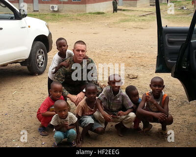 Major Luke A. Sauber, Memphis, Tennessee, native und Offizier-in-Gebühr von Security Zusammenarbeit Team 4 mit Spezial-Marine Air-Ground Task Force Afrika, posiert für ein Foto mit Kindern in Burundi, 25. August 2014, während der Beratung die Burundi National Defense Force. Marines sind die afrikanischen Partnernationen, regionale Sicherheitsprobleme Beratung. (Foto mit freundlicher Genehmigung) SP-MAGTF Afrika 14 führt Sicherheit Zusammenarbeit Theaterengagement in Burundi 140825-M-MC123-143 Stockfoto