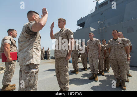 US Marine Corp Sgt. James Collier, Center, Bekämpfung von Logistik-Bataillon 22, 22. Marine Expeditionary Unit (MEU), Werkzeug Zimmer Unteroffizier und gebürtig aus Long Beach, Kalifornien, reenlists an Bord der amphibischen Transportschiff der Dock USS Mesa Verde (LPD-19). Die 22. MEU wird mit der Bataan amphibische bereit Gruppe als ein Theater-Reserve und Krise-Reaktionskräfte US Central Command und den USA bereitgestellt 5. Flotte Aufgabengebiet. (Foto: U.S. Marine Corps CPL. Manuel A. Estrada/freigegeben) CLB-22 Marine reenlists auf hoher See 140902-M-MX805-012 Stockfoto