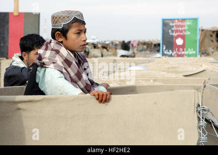 Ein afghanischer Junge Uhren als afghanische Nationalpolizei und Marines mit Firma K, 3. Bataillon, 8. Marineregiment (Stahlbeton), führen eine Patrouille durch einen örtlichen Basar in Farah Provinz, Islamische Republik Afghanistan, Jan. 24. 3/8 ist das Grundkampfelement von speziellen Zweck Marine Air Ground Task Force - Afghanistan. Durch die Partnerschaft mit den afghanischen Sicherheitskräften, stärkt SPMAGTF-A die Fähigkeit der Regierung der islamischen Republik Afghanistan zum Schutz der Bevölkerung. Marines, afghanische Polizei patrouillieren Farah Provinz DVIDS148972 Stockfoto