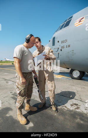 US Air Force Tech SGT Jarrod Blanford, links, eine Antenne Porter mit der 123. Kontingenz Response Group, Kentucky Air National Guard, Bewertungen ein Fracht-Manifest mit Flieger 1. Klasse Evan Kuehl, Loadmaster mit dem 86th Airlift Wing, vor der Abreise eine c-130 Hercules-Flugzeuge auf Léopold Sédar Senghor International Airport in Dakar, Senegal, 22. Oktober 2014, auf dem Weg nach Liberia, US-Truppen für Betrieb United Hilfe zu unterstützen. Vereinte Hilfe ist eine US-Verteidigungsministerium Operation Befehl und Steuerung, Logistik, Schulung und technische Unterstützung für US-Personen Stockfoto