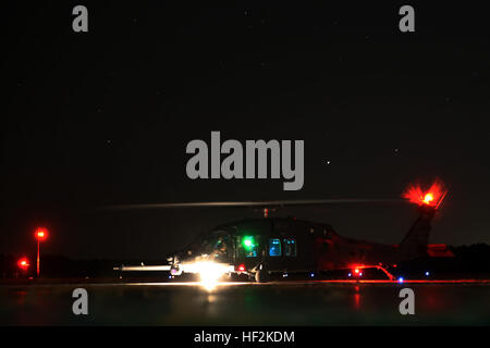 Piloten von einem UH-60 Black Hawk erwarten Marines mit Marine Aerial auftankenden Transport-Geschwader 252 Kraftstoffschlauch von einem KC-130J Super Hercules während Luft geliefert Boden Tanken Ausbildung bei Wright Army Airfield, Ga., 22. Oktober 2014 anschließen. ADGR kann Flugzeuge, die nicht in der Lage, während des Fluges landen, tanken und wieder aufnehmen Unterstützungsmission tanken. Die Blackhawks gehören zu der Armee 160th Special Operations Aviation Regiment (Airborne) und Super Hercules gehört zu den Marines der Marine Aerial auftankenden Transport Geschwader 252. VMGR-252 führt AR, Luft-geliefert Boden Tanken 141022-M-BN069-094 Stockfoto