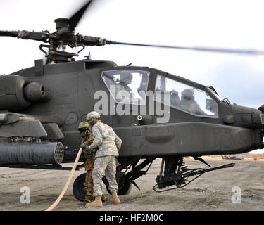 US Army Spc. Richard Mackey, ein auftankenden zugewiesen Firma E, 3. Bataillon, 25. Combat Aviation Regiment von Wheeler Field, Hawaii und Sgt. Yuta Kurita, eine Crew-Chief der JGSDF 7. Luftfahrt-Einheit aus Sapporo, Japan, zugeordnet tanken ein US AH-64 "Apache" Hubschrauber während Orient Shield 14 hier, Okt. 28. Die Luftfahrt-Refuelers unterstützen Soldaten aus dem 2. Stryker Brigade Combat Team, 2. Infanterie-Division von Joint Base Lewis-McChord, Washington, und JGSDF Mitglieder aus der 11. Infanterie-Regiment, 7. Division Nordarmee Bereich Training Übungen, 27 Okt. – 7. November. U.S. ein Stockfoto